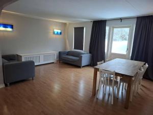 a living room with a table and chairs and a couch at Workers Stay - Construction Worker Housing in Gothenburg +14 photos