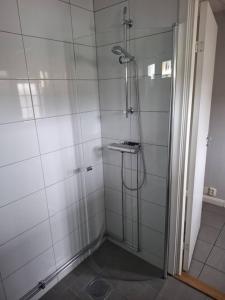 a shower with a glass door in a bathroom at Workers Stay - Construction Worker Housing in Gothenburg