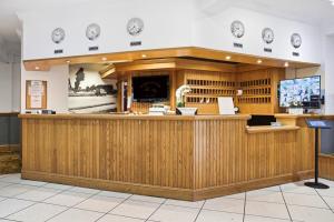a restaurant with a wooden counter in a room at The Greyhound Hotel in Leigh