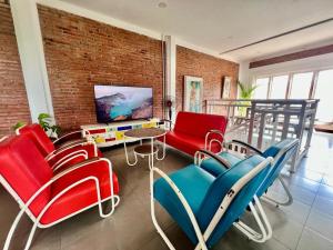 a living room with red and blue chairs and a tv at PaddyView Hostel in Banyuwangi