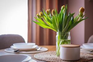 a vase of tulips sitting on a table at Apartament P27 in Sztutowo