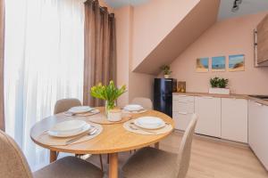 a kitchen and dining room with a wooden table and chairs at Apartament P27 in Sztutowo