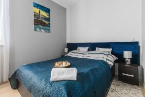 a bedroom with a blue bed with a tray on it at Apartament P27 in Sztutowo +14 photos