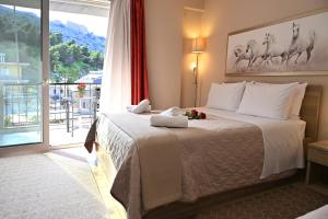 ein Hotelzimmer mit einem Bett und einem großen Fenster in der Unterkunft Hotel Vasilis Nafplio in Nafplio