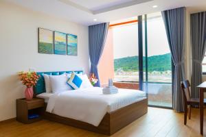 a bedroom with a bed and a large window at The Sea Light Hotel Phú Quốc- Sunset and Ocean View in Phú Quốc +94 photos