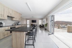 a kitchen with a counter and a bar with stools at Uitzicht in Springbok