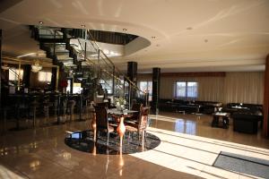 a lobby with a table and chairs and a staircase at Hotel Kotva in Bratislava