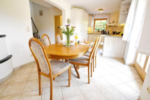 a kitchen and dining room with a wooden table and chairs at Haus Nini in Chieming