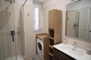 a bathroom with a sink and a washing machine at Open Space Suite in the Center of Salerno, modern apartment into Historic District, 250 meters from seafront and 20 meters from the Main Street Corso Garibaldi in Salerno +18 photos