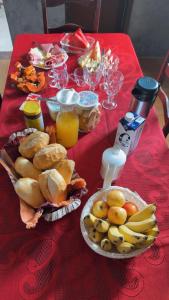 a red table topped with plates of food and fruit at Pousada Bem estar in Divinópolis