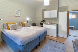 a bedroom with a large bed and a kitchen at Villa Lepola Sauna Suite in Rovaniemi +2 photos