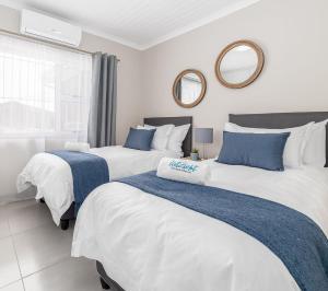 two beds in a room with two mirrors at Uitzicht in Springbok
