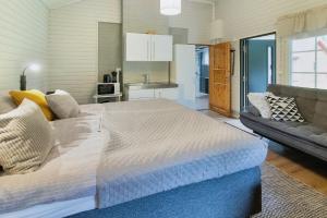 a bedroom with a large bed and a couch at Villa Lepola Sauna Suite in Rovaniemi
