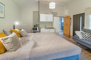 a large white bed in a room with a couch at Villa Lepola Sauna Suite in Rovaniemi