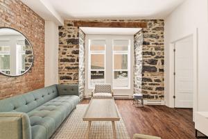 a living room with a couch and a brick wall at Meramont Hotel Downtown in Montreal