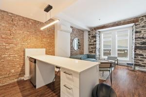 an open kitchen and living room with a brick wall at Meramont Hotel Downtown in Montreal
