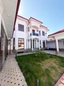 a large white house with a lawn in front of it at Emirate Plaza in Sergeli