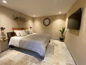 a bedroom with a bed and a clock on the wall at Haut Charmes de Cornil in Cornil