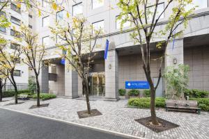 un gruppo di alberi di fronte a un edificio di HOTEL MYSTAYS PREMIER Omori a Tokyo