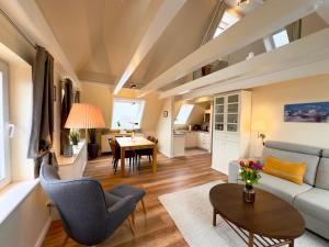 a living room with a couch and a table at Deichhof Whg 26 in Dunsum