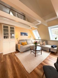 a living room with a couch and a table at Deichhof Whg 26 in Dunsum
