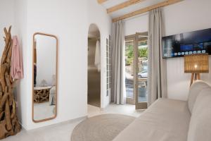 a living room with a couch and a mirror at Miles Away Residences in Platis Gialos