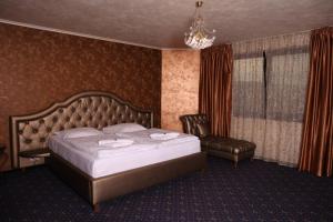 a bedroom with a large bed and a chair at Hotel Kotva in Bratislava