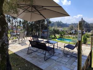 a patio with a table and chairs and an umbrella at Casas de Correndelos in Ponte de Lima