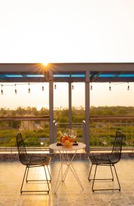 two chairs and a table on a balcony with the sunset at The Sea Light Hotel Phú Quốc- Sunset and Ocean View in Phú Quốc