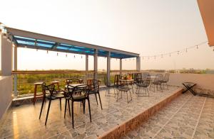 a patio with tables and chairs on a balcony at The Sea Light Hotel Phú Quốc- Sunset and Ocean View in Phú Quốc