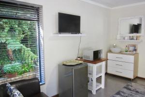 a room with a desk with a microwave and a window at Pecan Tree Forest Studio B with Terrace in Stellenbosch +48 photos