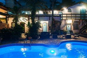 a pool in front of a house at night at Casa Aldeia Paraty in Paraty