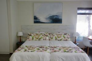 a bedroom with a white bed with flowers on it at Pecan Tree Forest Studio B with Terrace in Stellenbosch