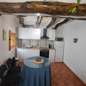 a kitchen with a table in the middle of a room at La Casilla de la Fuente in Trevélez