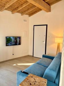a living room with a blue couch and a tv at Antico Borgo San Zeno in Bardolino