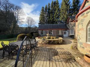 a patio with a fountain in front of a house at Bleaton Hallet House Riverside Escape in Kingseat