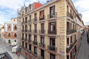 an apartment building with balconies on a city street at Malasaña & Plaza España in Madrid