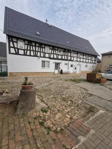 a large white building with a black roof at Gästewohnung Schönfeld in Frohburg