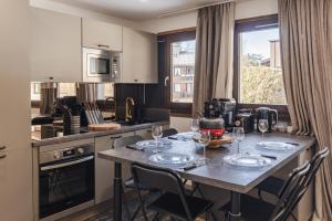 a kitchen with a table with wine glasses on it at Les Caribous - Lac 1 min, Espace Diamant, Megeve in Praz-sur-Arly