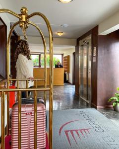 a woman in a hotel room with her luggage at Hotel Germania in Puerto Varas
