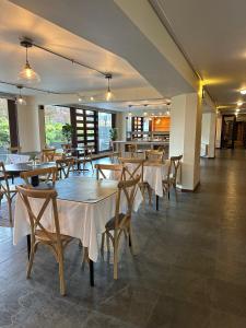 a restaurant with tables and chairs in a room at Hotel Germania in Puerto Varas