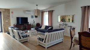 a living room with a couch and chairs and a tv at Casas de Correndelos in Ponte de Lima