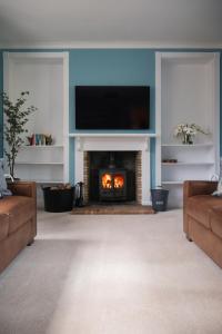 a living room with a fireplace with a tv above it at Bleaton Hallet House Riverside Escape in Kingseat