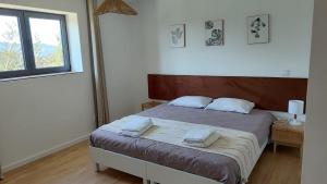 a bedroom with a bed with two towels on it at Casas de Correndelos in Ponte de Lima +37 photos
