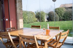 a wooden table with a bottle and two glasses of wine at GuestHost - Casa delle Querce Villa with Pool in Gropparello