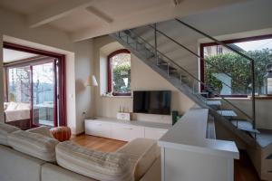 a living room with a staircase and a couch at GuestHost - Casa delle Querce Villa with Pool in Gropparello