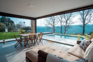 a living room with a table and chairs and a pool at GuestHost - Casa delle Querce Villa with Pool in Gropparello