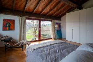 a bedroom with a bed and a large window at GuestHost - Casa delle Querce Villa with Pool in Gropparello +30 photos