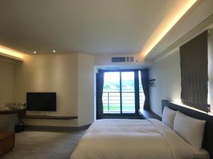 a bedroom with a large bed and a television at 稻花香民宿 in Chishang