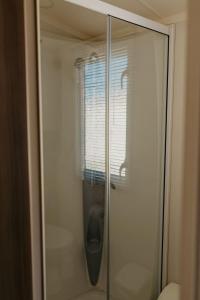 a glass shower door with a window in a bathroom at Lower Cliff 19 in Easton +7 photos